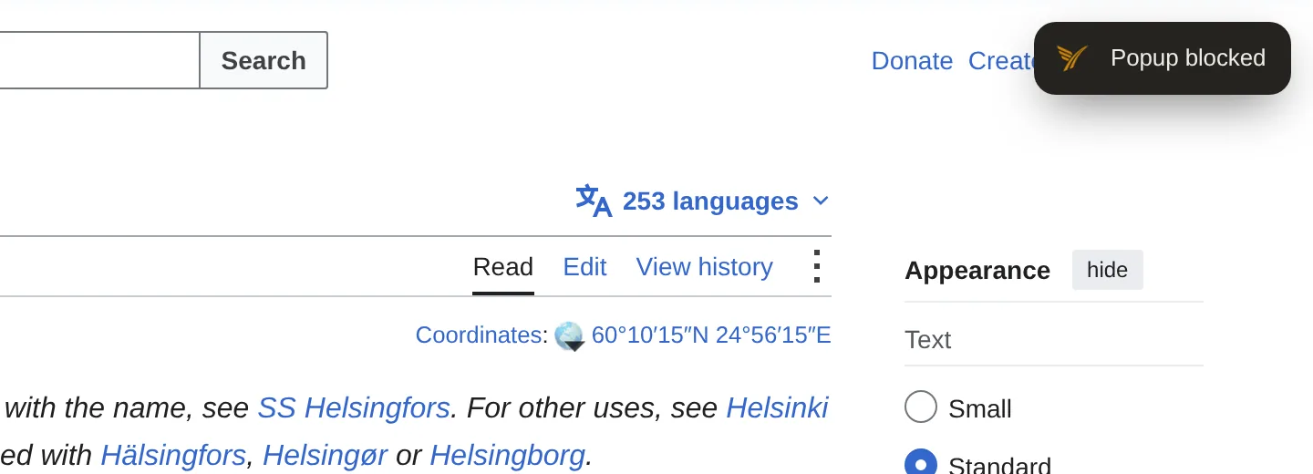 Hinweis „Popup blockiert“ von SuperchargePerformance oben rechts in einem Wikipedia-Artikel über Helsinki.